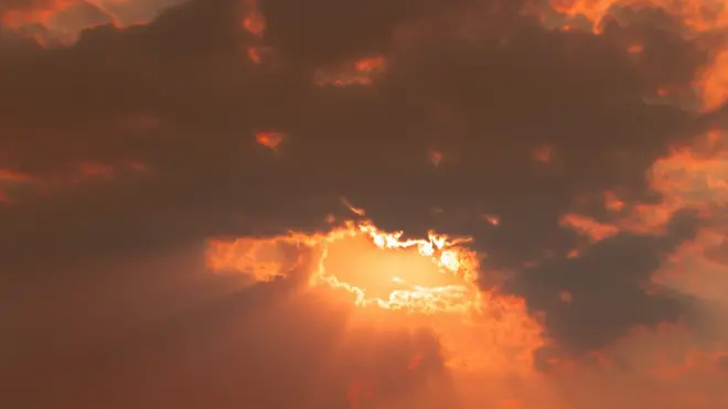 Trou orange vif dans un ciel orange foncé et lumière rouge