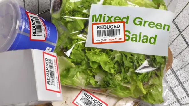 Picture of a shopping basket full of groceries with reduced stickers