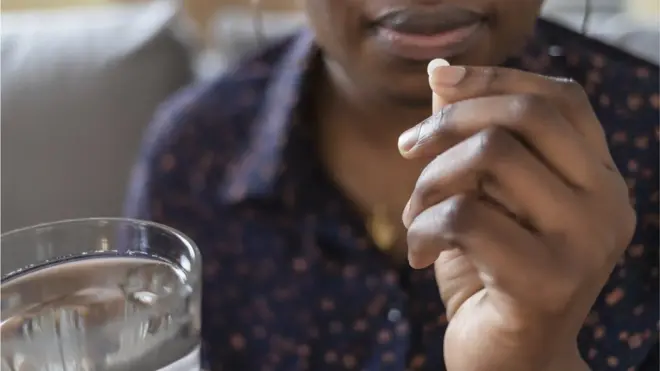 Une femme qui prend un comprimé