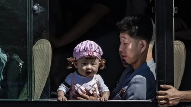 평양 버스 안에 탄 아빠가 아기를 안고 있다