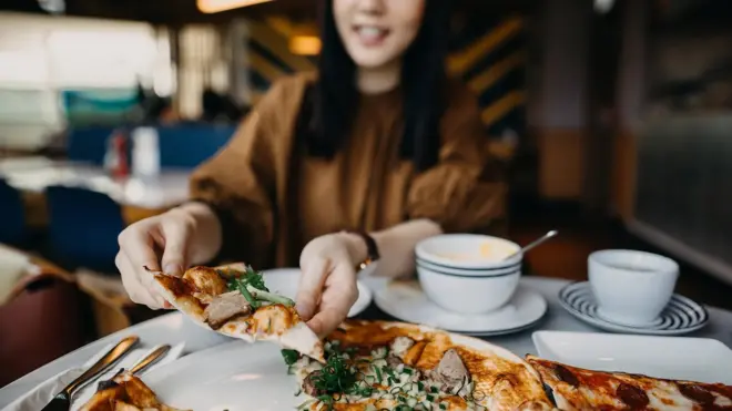 Mulher pegando um pedaçojogo de 5 centavos pixbetpizza