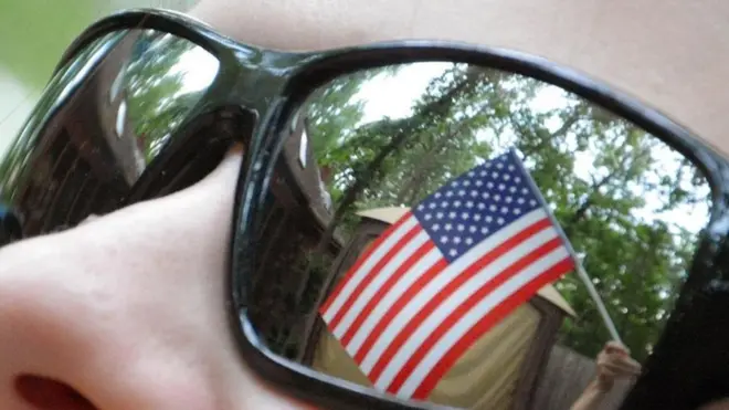 Una bandera estadounidense reflejada en unos lentes de sol