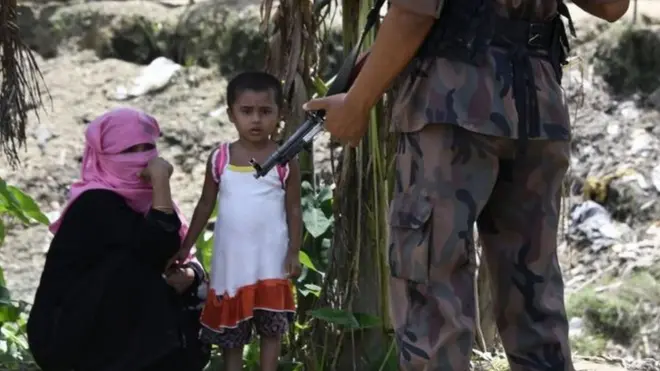 Aparat keamanan Bangladesh berjaga di dekat perempuan dan anak dari etnik Rohingya.