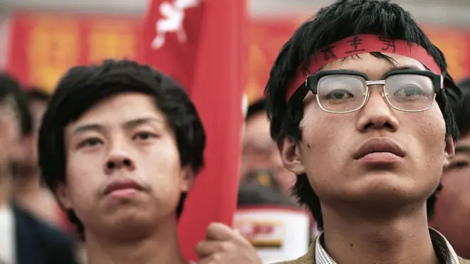 Hai sinh viên tham gia Phong trào sinh viên mùa hè 1989 đứng lắng nghe một lãnh đạo sinh viên phát biểu tại Quảng trường Thiên An Môn