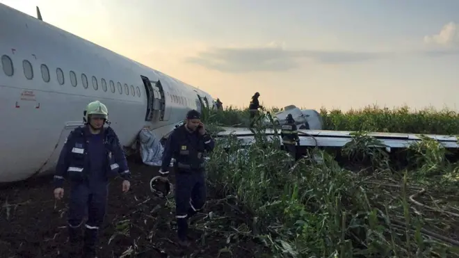 구조팀이 동체 착륙한 러시아 여객기를 살펴보고 있다