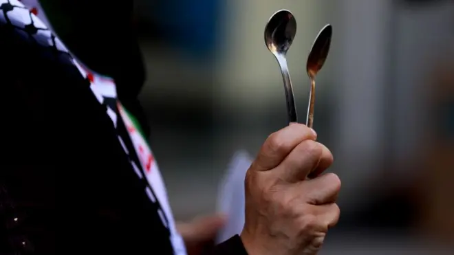 متظاهرة في مدينة غزة تحمل ملعقة، أداة الحفر التي استخدمها ستة سجناء فلسطينيين فروا من سجن جلبوع الإسرائيلي