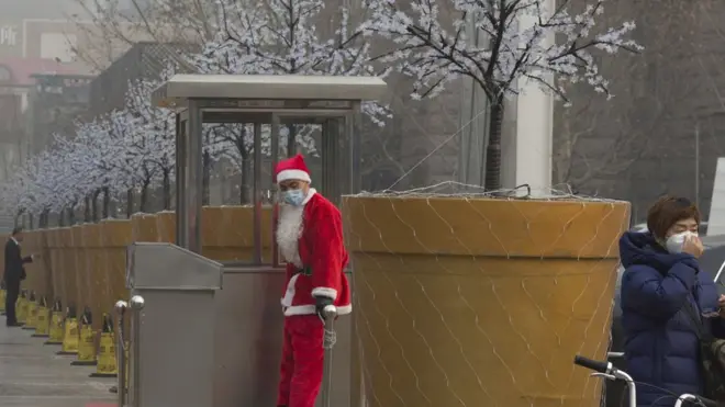 12月21日，北京陷入霧霾紅色警報。一名扮成聖誕老人的停車員戴上了口罩。新一次的空氣污染預警距離上次霧霾天氣結束不到兩周。