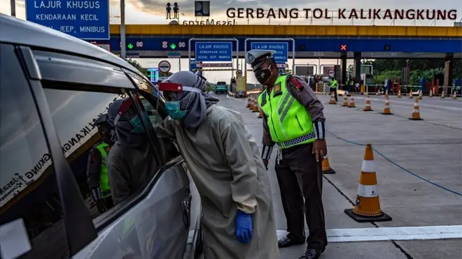 Petugas kesehatan memeriksa suhu pengendara roda empat saat penyekatan pemudik di Gerbang Tol Kalikangkung, Semarang, Jawa Tengah, Selasa (26/05). Sebanyak 276 mobil dan maupun bus yang mengangkut pemudik menuju DKI Jakarta di gerbang tol itu diperintahkan memutar balik karena tidak SIKM.