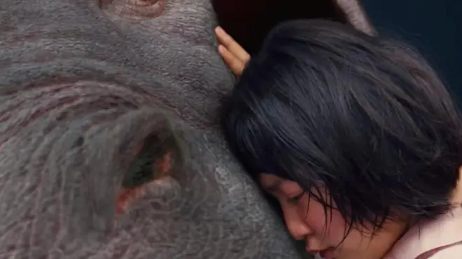 Okja dipelihara di pegunungan berhutan lebat Korea oleh seorang anak perempuan baik hati, Mija (Seo Hyun An).