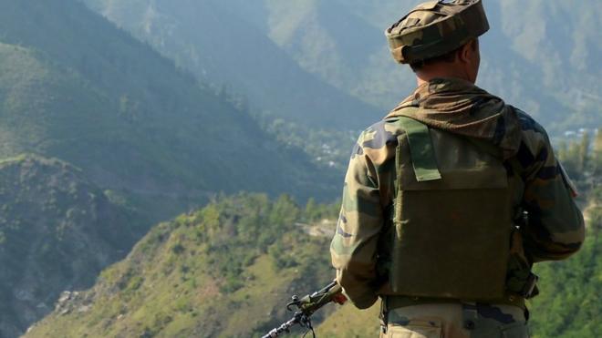 An Indian army soldier looks towards the site of a gun battle between Indian army soldiers and rebels inside an army brigade headquarters near the border with Pakistan, known as the Line of Control, in Uri. Taken on 18 September 2016.