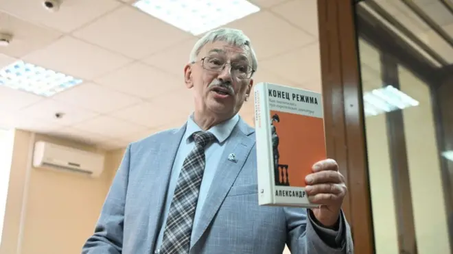 Oleg Orlov muestra la portada de un libro en el tribunal de Moscú.