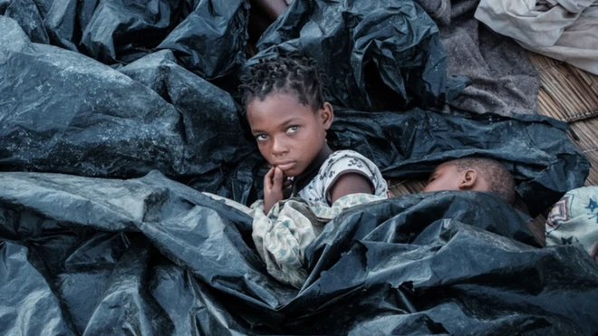 A child seeks shelter from a cyclone in Mozambique