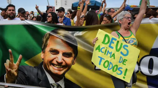 "Бог - над всеми" - это часть предвыборного лозунга Жаира Болсонару