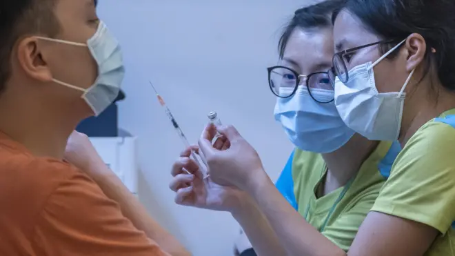 香港某社区疫苗接种中心内两位女工作人员准备施打科兴新冠病毒疫苗(23/2/2021)