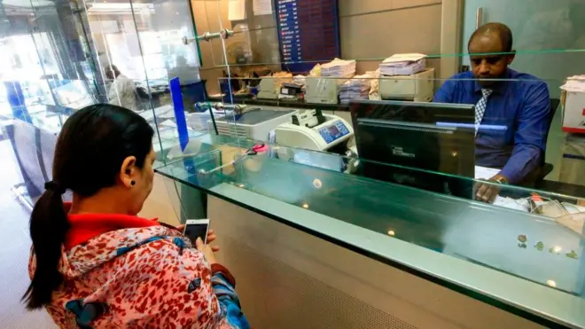 امرأة تنتظر معاملتها في مكتب صرافة في الخرطوم