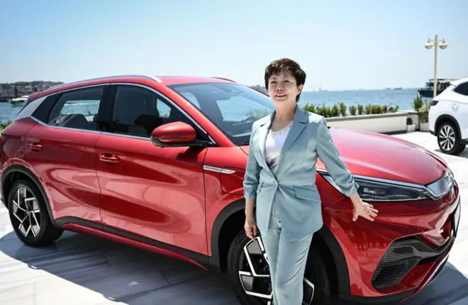 BYD'nin başkan yardımcısı ve BYD Americas'ın CEO'su Stella Li, 10 Temmuz 2024'te İstanbul'daki Four Seasons Otel'de kırmızı bir otomobilin yanında.