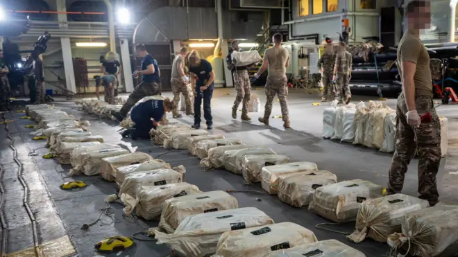 Security operatives inspecting sacks suspected to contain cocain seized from a fishing boat off the gulf of guinea