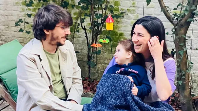 Pablo, Almudena y Laia sentados en una tumbona en un jardín interior.