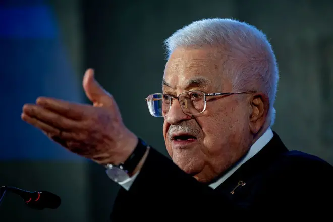 رئيس السلطة الفلسطينية محمود عباس يرفع يده