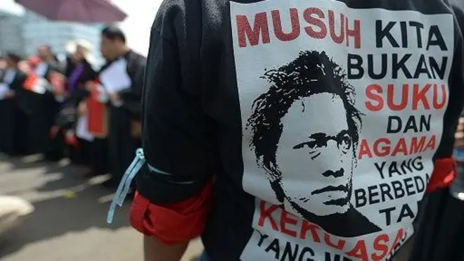 Seorang pengunjuk rasa Indonesia mengenakan kaos bertuliskan, "Musuh kita bukanlah keberagaman agama atau ras, melainkan pemerintah yang menindas" dalam protes terhadap kegagalan pemerintah Indonesia dalam menjamin kebebasan beragama di Jakarta pada tanggal 8 April 2013.