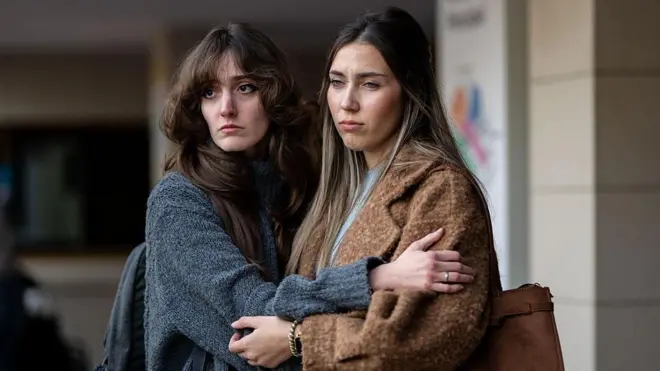 Дві жінки тримаються за руки