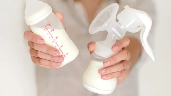 မိခင်နို့ရည် ပုလင်းကို ကိုင်ထားတဲ့ အမျိုးသမီးတစ်ဦး