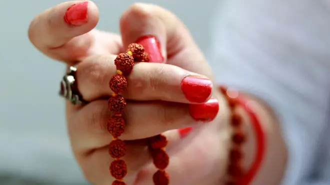 रुद्राक्षांचे मणी ओढणाऱ्या महिलेचा हात