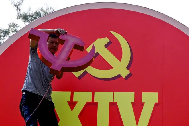 Một người đàn ông đang lắp đặt bảng quảng cáo cho Đại hội Đảng Cộng sản Việt Nam lần thứ 14 tại Hà Nội vào ngày 9/1/2026