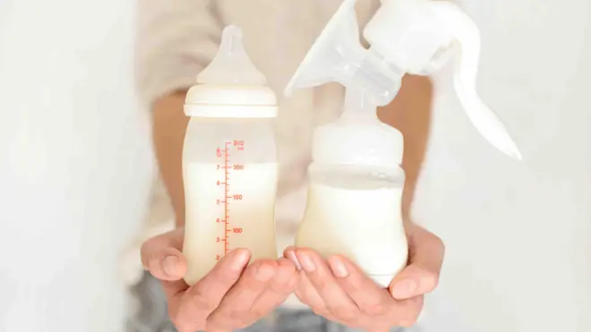 One photo of one woman wey hold breast milk bottle and milk pump
