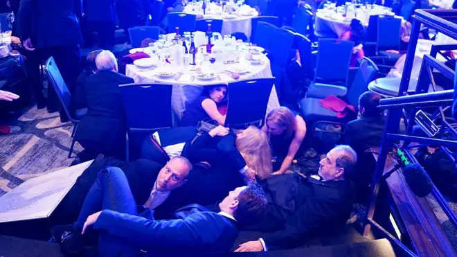 WASHINGTON, DC - APRIL 25: Attendees hide under tables after an incident at the annual White House Correspondents Association Dinner April 25, 2026 in Washington, DC. According to reports, President Donald Trump, along with other government officials, were evacuated from the Washington Hilton after what sounded like gun fire