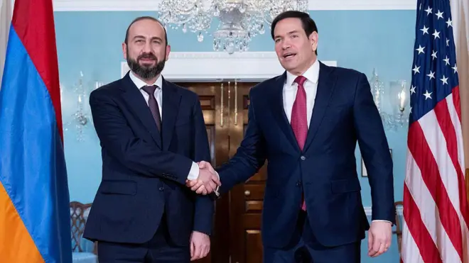 Rubio ve Mirzoyan tokalaşıyor. Arkalarında kendi ülkelerinin bayrakları var.