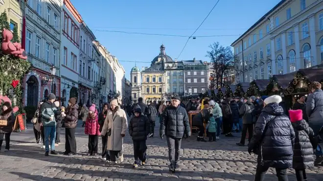 Місто львів, площа ринок, люди на вулиці одягнені в зимовий одяг