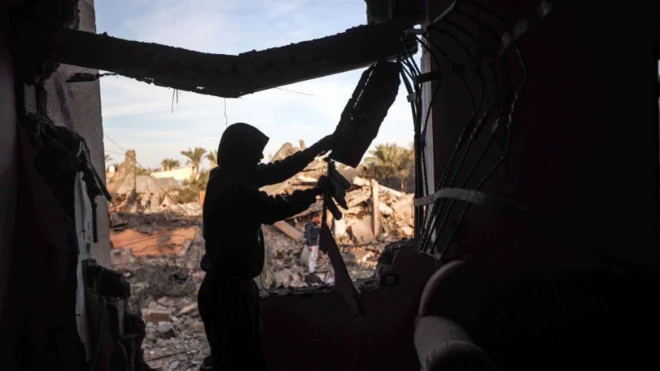 رجل يتفقد منزله إثر غارة إسرائيلية في دير البلح بقطاع غزة، يوم 15 يناير/كانون الثاني 2025