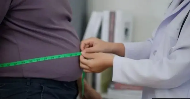 Aworan ọkunrin to wa pẹlu dokita to n wọn ikun rẹ.