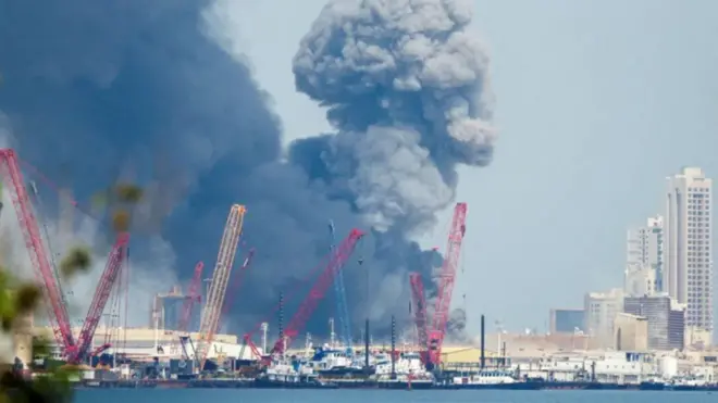 Plumes of black smoke dey rise above one area near di headquarters of di US Navy Fifth Fleet