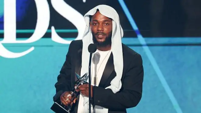 Kendrick Lamar wear white shirt wit black blazzers and white headscarf, pose wit im BET Awards.