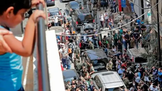 طفل ينظر من الشرفة إلى تجمع ناس