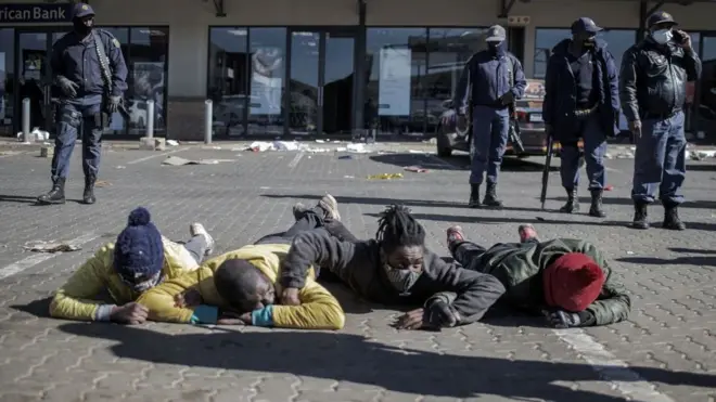 Suspected looters lie for ground as South African Police Service (SAPS) officers catch dem for one mall for Soweto on July 13, 2021.