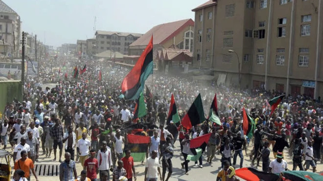 Plenty Biafra supporters dey wave flags and sing songs as dem dey march enter streets for Aba, southeastern Nigeria.