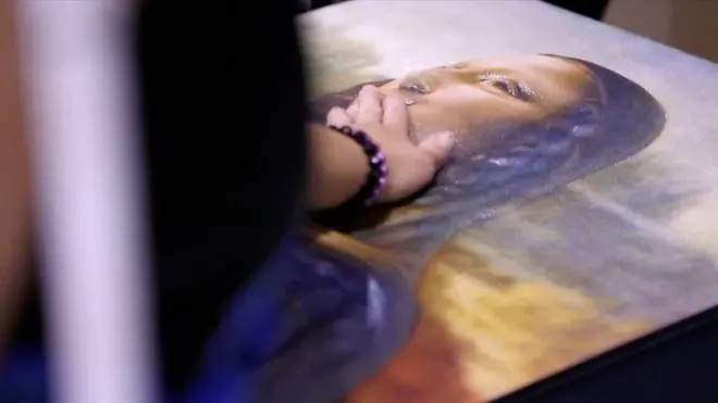 Pessoa toca reprodução em 3D da Mona Lisa