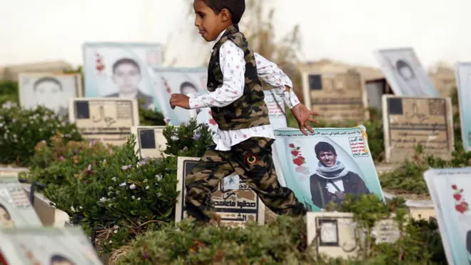 طفل يمني يركض بين مقابر في العاصمة صنعاء، حزيران/يونيو.