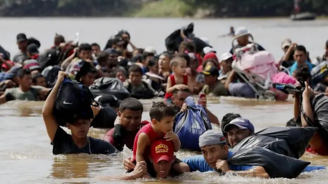 Rombongan migran, sebagian besar berasal dari Honduras, menyeberangi Sungai Suchiate yang memisahkan Guatemala dan Meksiko pada 29 Oktober 2018.