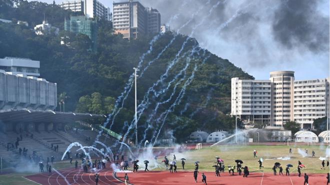 Protesters react after police fired tear gas at the Chinese University of Hong Kong (CUHK), in Hong Kong on November 12, 2019