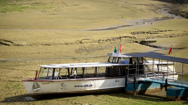 A boat trapped in the dried out shore where the French-Swiss Lac de Brenets lake should be