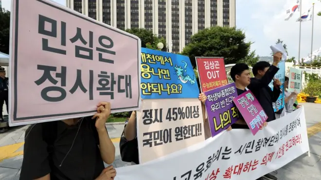 한 시민단체 회원들이 정부서울청사 앞에서 '민심은 정시 확대'라는 피켓을 들고 서 있다