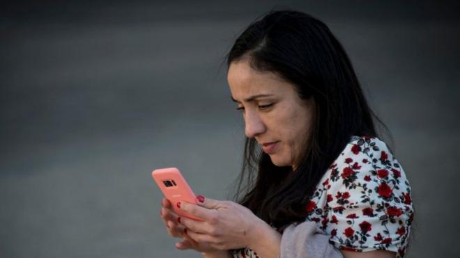 Mujer usando un celular en Santiago de Chile