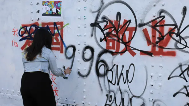 倫敦紅磚巷一位女子在中國政治標語上反制塗鴉（6/8/2023）