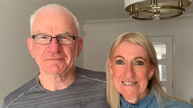 мушкарац и жена гледају у камеру