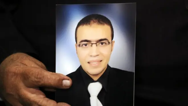 里达‧哈马迈手持儿子阿卜杜拉‧哈马迈的照片受访，称儿子不是恐怖份子。并强调儿子没有蓄胡。虔诚的穆斯林才会蓄胡。