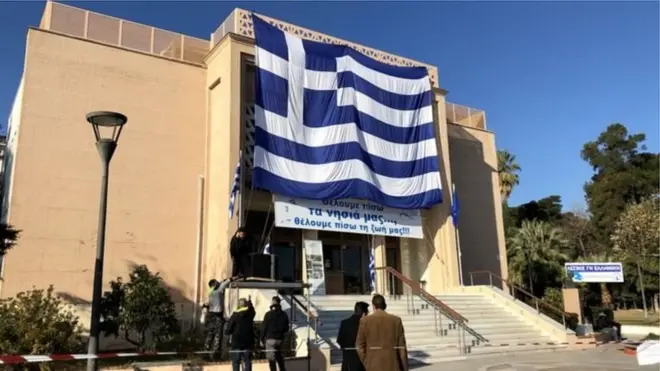 Midilli adasında asılı pnakartta "Adalarımızı geri istiyoruz, hayatlarımızı geri istiyoruz" yazıyor.